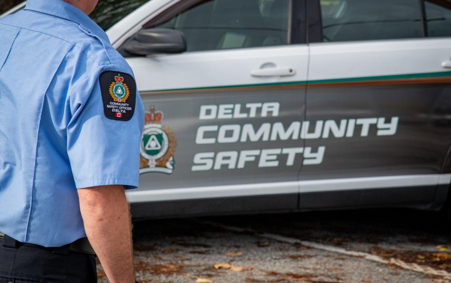 Community Safety Officer in uniform, by branded vehicle